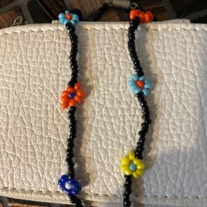 Black beaded necklace with colored flowers.